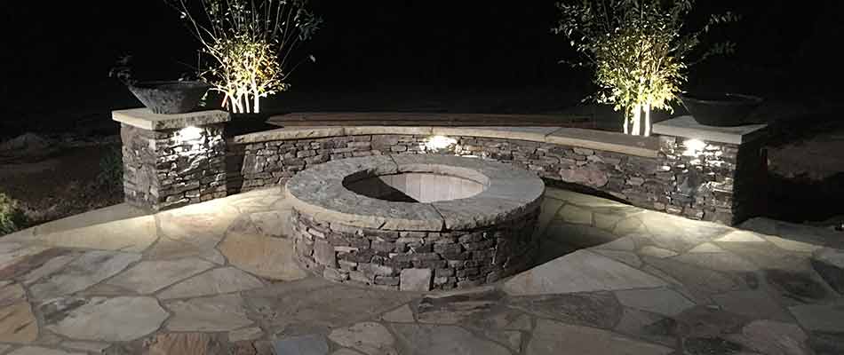 Fire pit partially encircled by an outdoor seating wall.