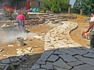 One of the Master's team members helping build a beautiful custom stone pathway.