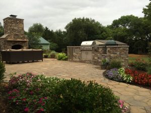 A lush green front yard with an outdoor kitchen 