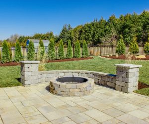 “Landscaped backyard with retaining wall and greenery for outdoor design.”