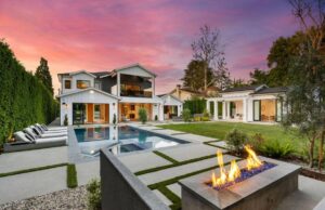 A client's backyard whose landscape design plans included outdoor fireplace near backyard pool.